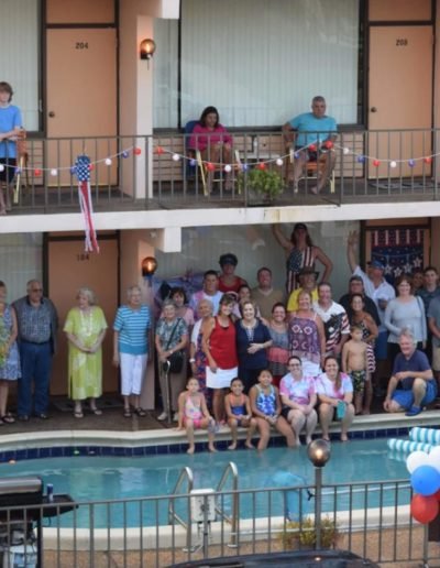 Photo of guests and staff posing around the pool.